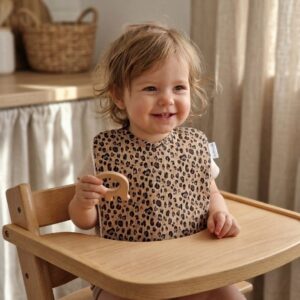 bavoir maternelle porté par un enfant lors d'un repas en chaise haute