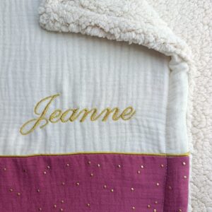 détail du prénom brodé sur une couverture personnalisée bébé en gaze de coton framboise dorée
